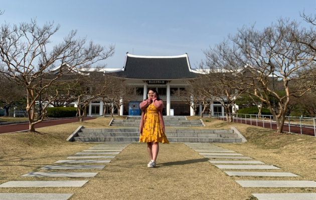 Kayla standing in the garden in front of a Korean museum