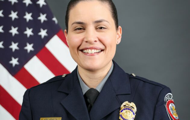 Portrait photo of female police officer in uniform with U.S. flag