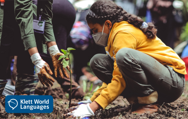 Young woman plants a tree sapling along with others; the Klett World Languages logo appears at the bottom left corner.