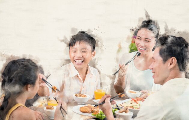 Parents and two children enjoy a meal around a table using chopsticks
