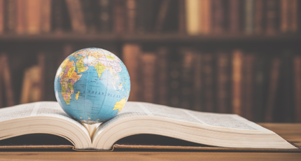 A small globe rests inside an open book